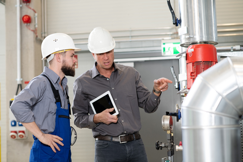 HVAC technicians working on a unit at a job site.
